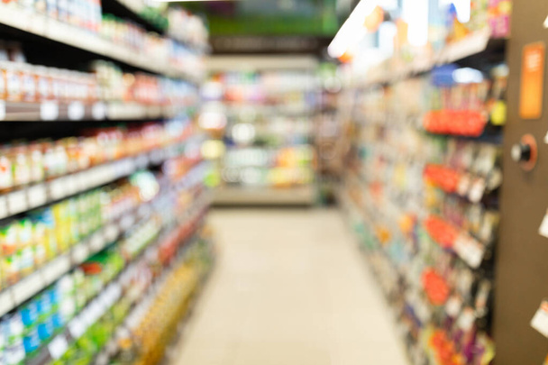 Homályos szupermarket háttér, élelmiszerbolt sorban polcok és termékek - Fotó, kép
