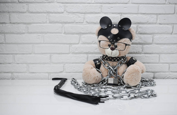 игрушечный медведь, одетый в кожаные ремни - Фото, изображение
