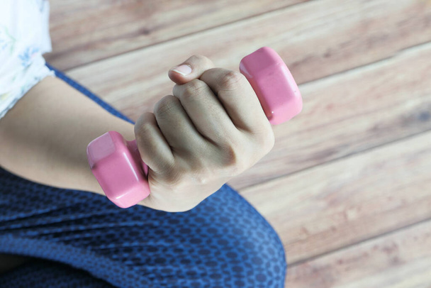 Young woman exercising with dumbbell weights top view  - Фото, изображение