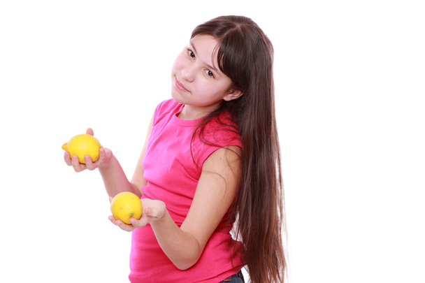 Caucasian beautiful little girl with fresh yellow lemons - Foto, Imagem