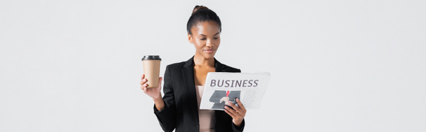 Afrikaans Amerikaans zakenvrouw met business krant en koffie te gaan geïsoleerd op grijs, banner - Foto, afbeelding
