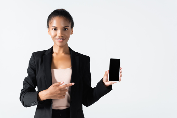 donna d'affari afro-americana sorridente che punta lo smartphone isolato sul grigio - Foto, immagini