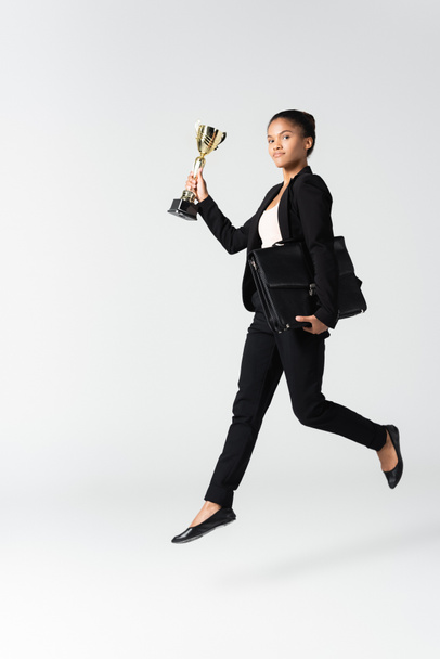 visão lateral da empresária afro-americana com mala e cálice isoladas em branco - Foto, Imagem