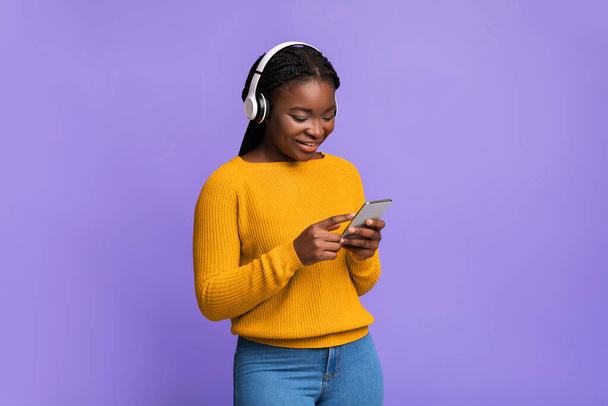 Modern Boş Zamanlar Teknolojileri. Smartphone ve kulaklıklı Siyahi Kadın Müzik Dinliyor - Fotoğraf, Görsel