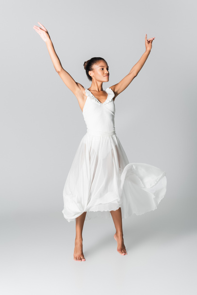 barefoot graceful african american ballerina in dress dancing on white background - Photo, Image