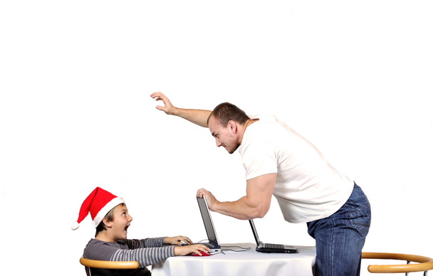 άνθρωπος απειλούν το παιδί με το καπέλο santa λόγω της χάσει παιχνίδι - Φωτογραφία, εικόνα