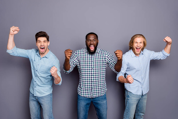 Portrait of three nice attractive cheerful cheery crazy overjoyed guys best buddy fellow fan celebrating breakthrough cup isolated over gray purple pastel color background - 写真・画像