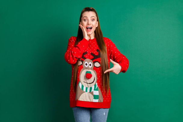 Portrait of her she nice-looking attractive charming cheerful cheery amazed ecstatic long-haired girl wearing demonstrating cozy look deer funky print isolated over green color background - 写真・画像