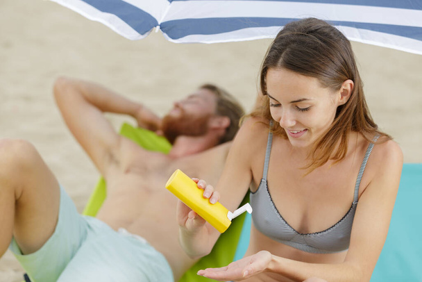young woman with healthy skin applying suncream - Photo, Image