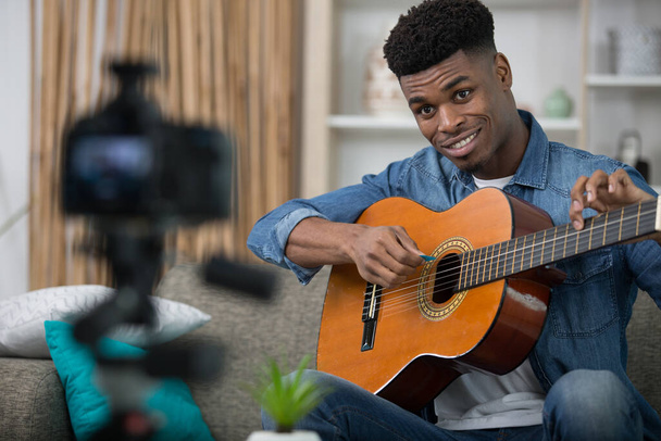 young handsome guy model smiles and poses with a guitar - Fotoğraf, Görsel