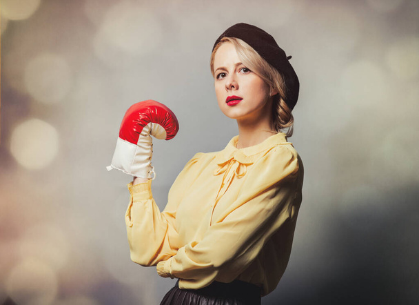 Kaunis tyttö vintage vaatteita nyrkkeily käsine harmaalla pohjalla - Valokuva, kuva