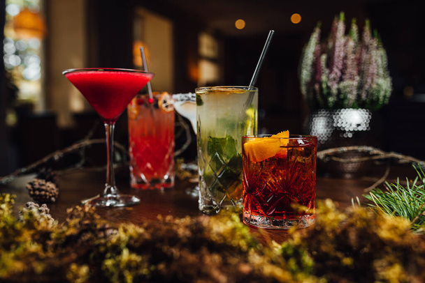 Διαφορετικά αλκοολούχα κοκτέιλ στο τραπέζι μπαρ με beutiful διακοσμήσεις - Φωτογραφία, εικόνα
