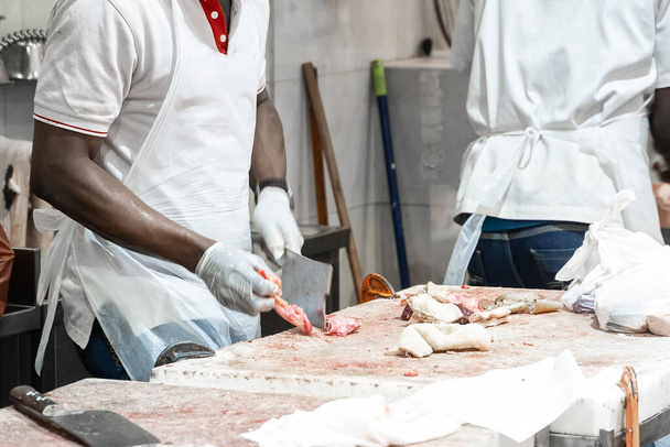 African american butcher cutting meat at counter in butchery. A man cook cut fresh bacon meat - Φωτογραφία, εικόνα