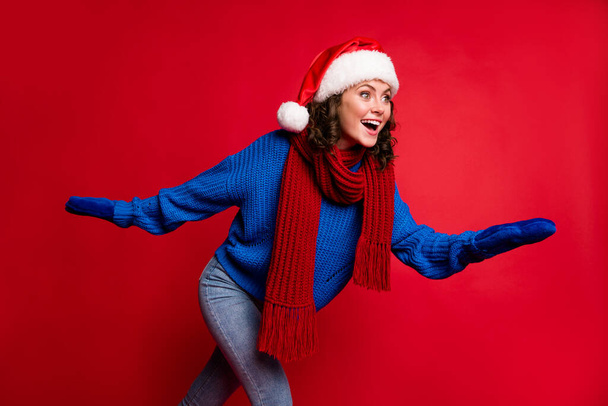 Portrait of her she nice attractive pretty glad cheerful cheery girl wearing Santa hat having fun skiing rolling skates pastime free time isolated bright vivid shine vibrant red color background - Fotoğraf, Görsel