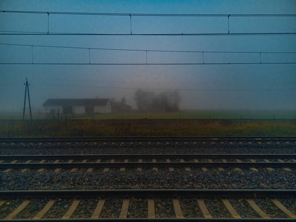 Morgennebel über Bahngleisen und kleiner Scheune - Foto, Bild