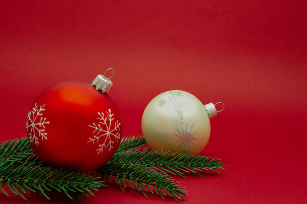 テキスト用スペース付きメリークリスマスカード。赤と赤の背景にモミの枝を持つ白いクリスマスツリーのおもちゃ - 写真・画像