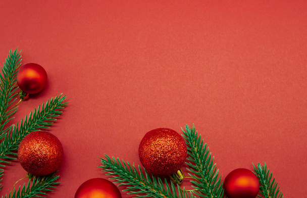 Червоні різдвяні кульки з ялиновими гілками на червоному тлі. Порожня для листівки з пробілом для тексту, плоска лінія
 - Фото, зображення