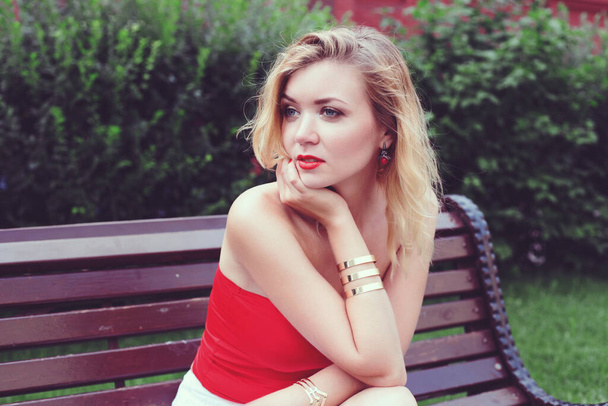 young beautiful girl in a white skirt and a red top. walking in the park and city. Toned in retro colors - Foto, imagen