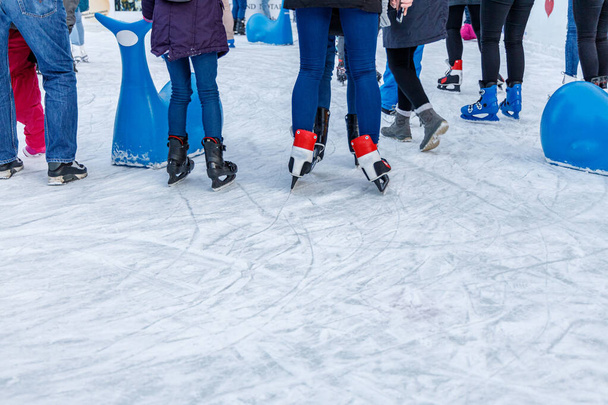 Jovens e crianças em uma pista de gelo pública, olhando para a superfície de gelo artificial, use como fundo ou para adicionar texto de cópia - Foto, Imagem