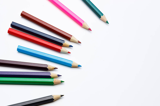 Top view of color pencils pointing to a target on white isolated background, for a powerpoint template or composition around school topics - Photo, Image