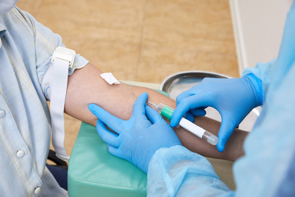 Hoitaja ottaa verinäytteen tehdä testi laboratoriossa - Valokuva, kuva