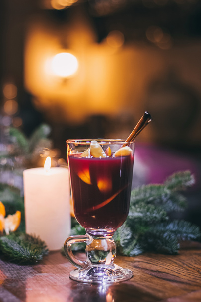 Red hot drink glintwein with spices, cinnamon, anise, fruits, brown sugar on an old wooden table. New Year and Christmas holidays concept. Mulled wine and glintwein - Photo, Image