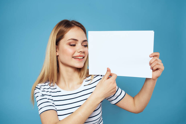 Женщина держит лист бумаги полосатая футболка скопировать пространство обрезанный вид синий фон - Фото, изображение