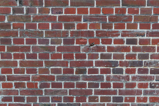Rode baksteen muur textuur met krassen, verwering en kleine scheuren en vuil, gebruiken als herhaalbare textuur voor een game asset. - Foto, afbeelding