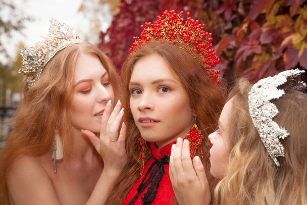 Russian girls are beautiful. Russian national traditions. Sisters in crowns. Wives from abroad. Girlfriends in red dresses. Fairy princesses. - Φωτογραφία, εικόνα