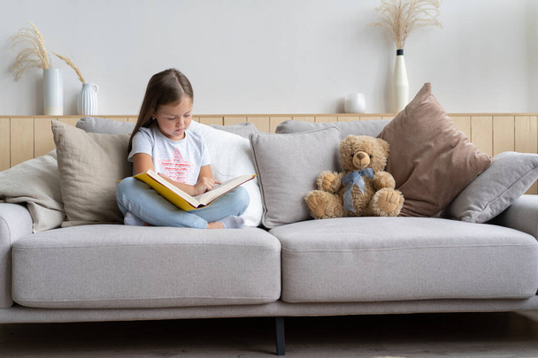 Young girl reading book at home. Distance education, home education. Self isolation concept. - Fotoğraf, Görsel