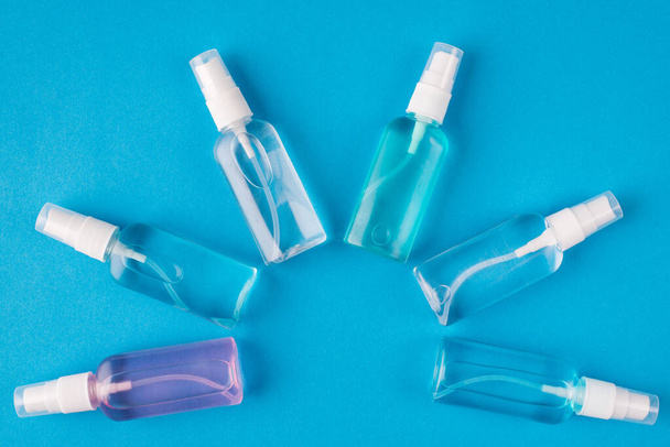 Hands hygiene concept. Top above overhead view photo of sanitizer bottles isolated on blue background - 写真・画像