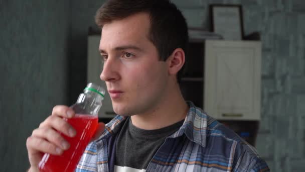 homme boire du jus de cerise dans une bouteille en plastique - Séquence, vidéo