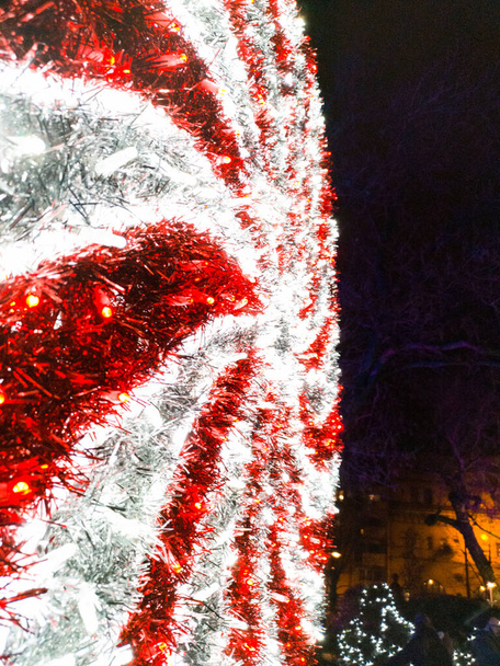 Gloeiende rode en witte kerstversieringen in het park 's nachts - Foto, afbeelding
