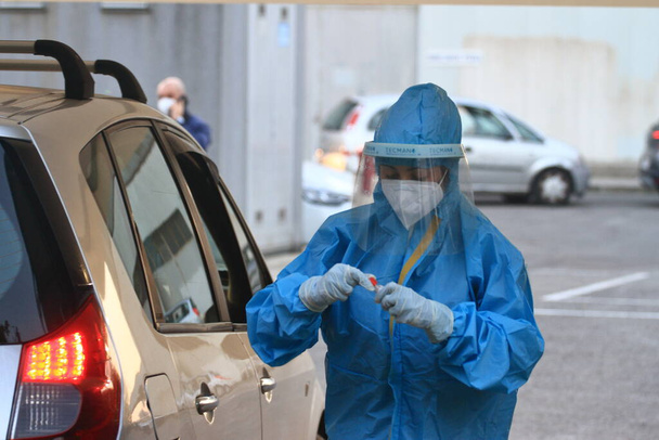 Nocera Inferiore, Salerno, Italia - marraskuu 09.2020: Lääkärit ottavat näytteen löytääkseen positiiviset puolet Covid-19:ssä. Näytteenotto drive-in-tilassa . - Valokuva, kuva