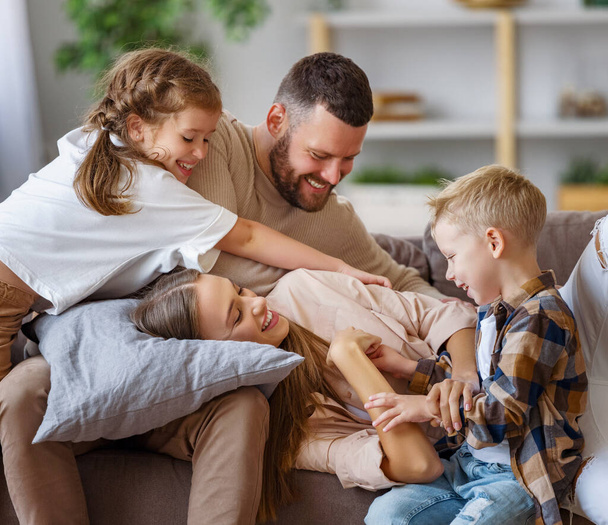 ευτυχισμένη οικογένεια μητέρα πατέρας και τα παιδιά διασκεδάζουν στο σπίτι στον καναπέ - Φωτογραφία, εικόνα