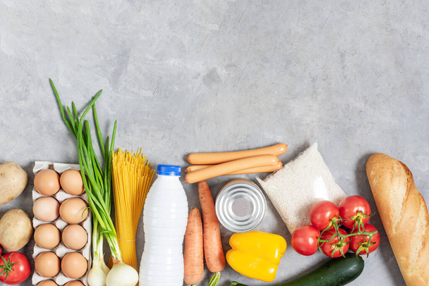 Variété de légumes et de produits d'épicerie sur table en béton gris. Contexte alimentaire sain. - Photo, image