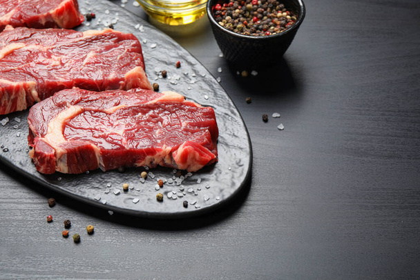 Fresh marbled meat steaks on slate board - Photo, image