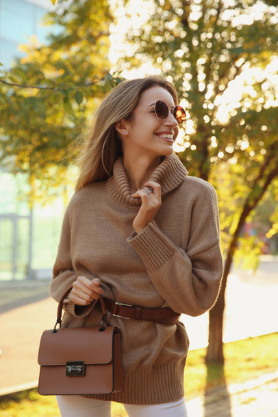 Beautiful young woman wearing stylish sweater in autumn park - Fotoğraf, Görsel