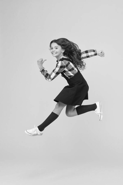 Break into. Feel inner energy. Girl with long hair jumping on yellow background. Carefree kid summer holiday. Time for fun. Active girl feel freedom. Fun and jump. Happy childrens day. Jump concept - Zdjęcie, obraz