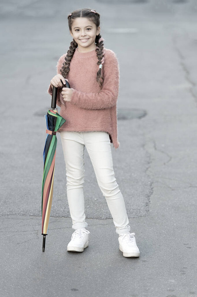 Ready for any weather. Girl child long hair ready meet fall weather with folded umbrella. Fall season. Colorful fall accessory positive influence. Brighten your fall mood. Carefree weekend walk - Photo, image