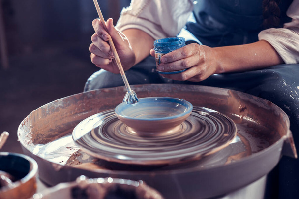 Ragazza ceramista dimostra il processo di fabbricazione di piatti in ceramica utilizzando la vecchia tecnologia. Concetto per donna in freelance, affari, hobby. Primo piano. - Foto, immagini