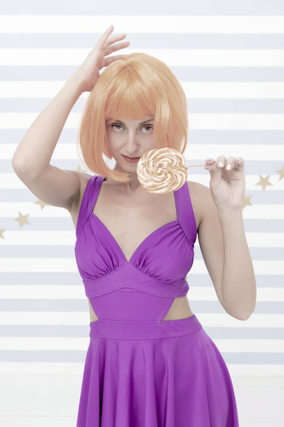 Fashion girl with orange hair having fun. Cool girl with lollipop. Sexy woman. happy pinup model with lollipop in hand. Crazy girl in playful mood. Going crazy. Enjoy party. Sweet look. So much fun - 写真・画像