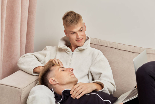 Couple of two men in love spend time at home together, lie at home on the couch. - Fotografie, Obrázek