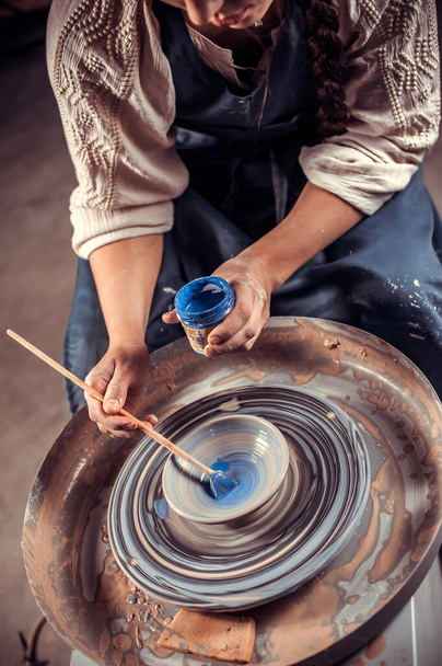 Ambtenaar meester werkt aan pottenbakkerswiel met rauwe klei met handen. Handwerk. Close-up. - Foto, afbeelding