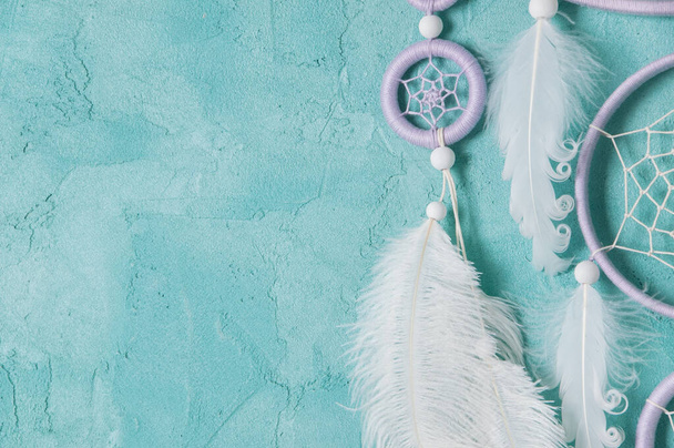 Lilac cream white dream catcher on aquamarine background. Copy space for text. - Фото, изображение