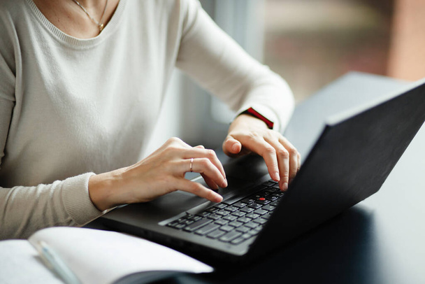 Woman hands are printed on a laptop - Φωτογραφία, εικόνα