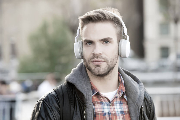 While walk. Online education courses. Listen music. Ebook audio concept. Student study use headphones. Handsome man urban background defocused. Distance education. Remote studying. Modern education - 写真・画像
