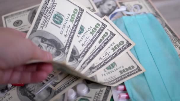 Mann hält Geld, Dollar für Kauf medizinischer Pillen, Spritze, Maske in der Hand - Filmmaterial, Video