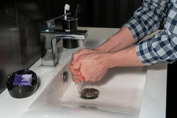 Washes his hands under the tap in the sink closeup - Photo, Image