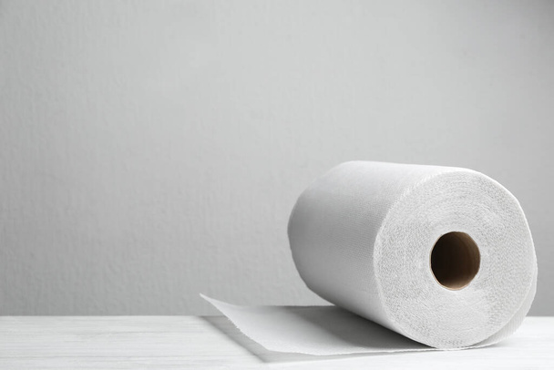 Roll of paper towels on white wooden table, space for text - Foto, imagen
